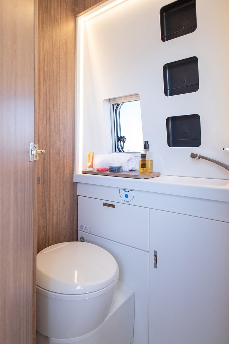 Lavabo y zona de aseo de la Weinsberg Carabus con muebles de almacenamiento.