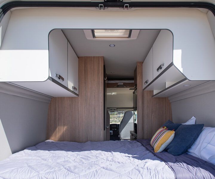 Vista trasera de la Weinsberg Carabus con la cama doble y mobiliario de almacenamiento