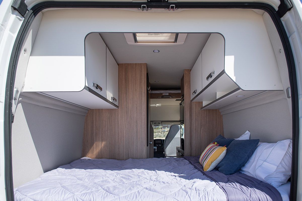 Vista trasera de la Weinsberg Carabus con la cama doble y mobiliario de almacenamiento